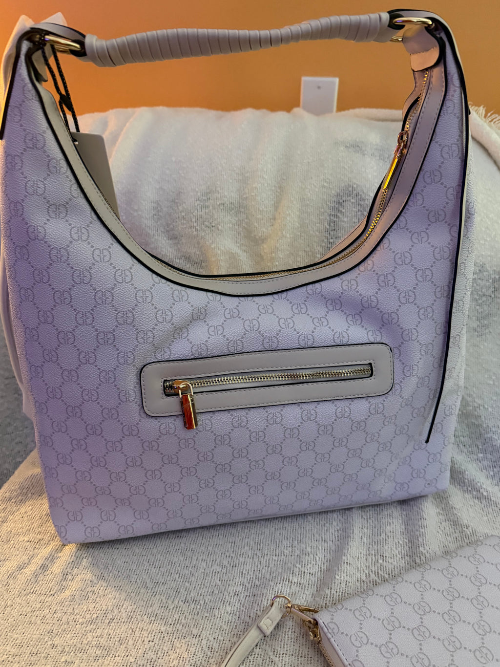 White/lavender monogram hobo bag showing front exterior zip pocket